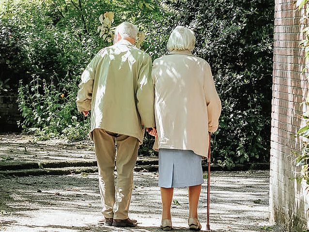 Para starszych osób podczas spaceru wśród zieleni