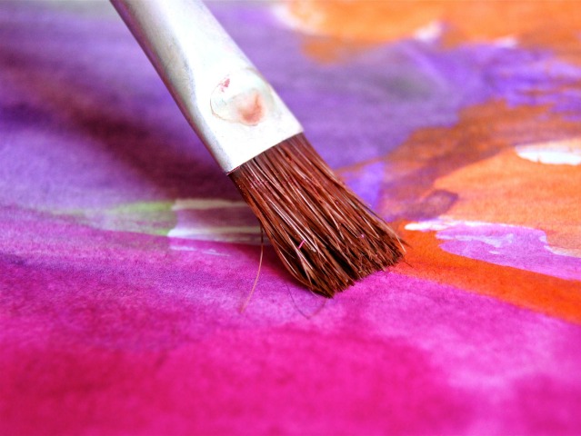 pędzel na kolorowym podłożu maluje